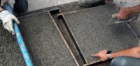 Construction workers applying permeable concrete